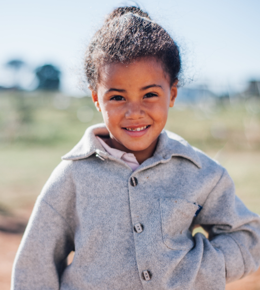 A shy little girl in South Africa – she and her family had stood in line for hours for some food that a local church was providing.