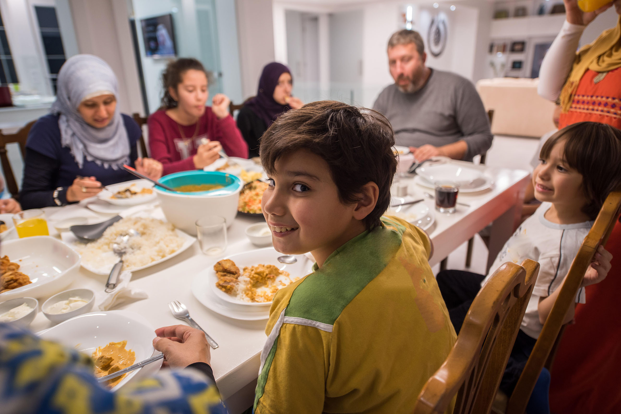 Muslim traditional family together having dinner on table at home