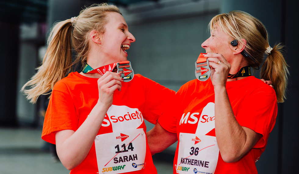 Two celebrating women wearing MS Society branded running gear